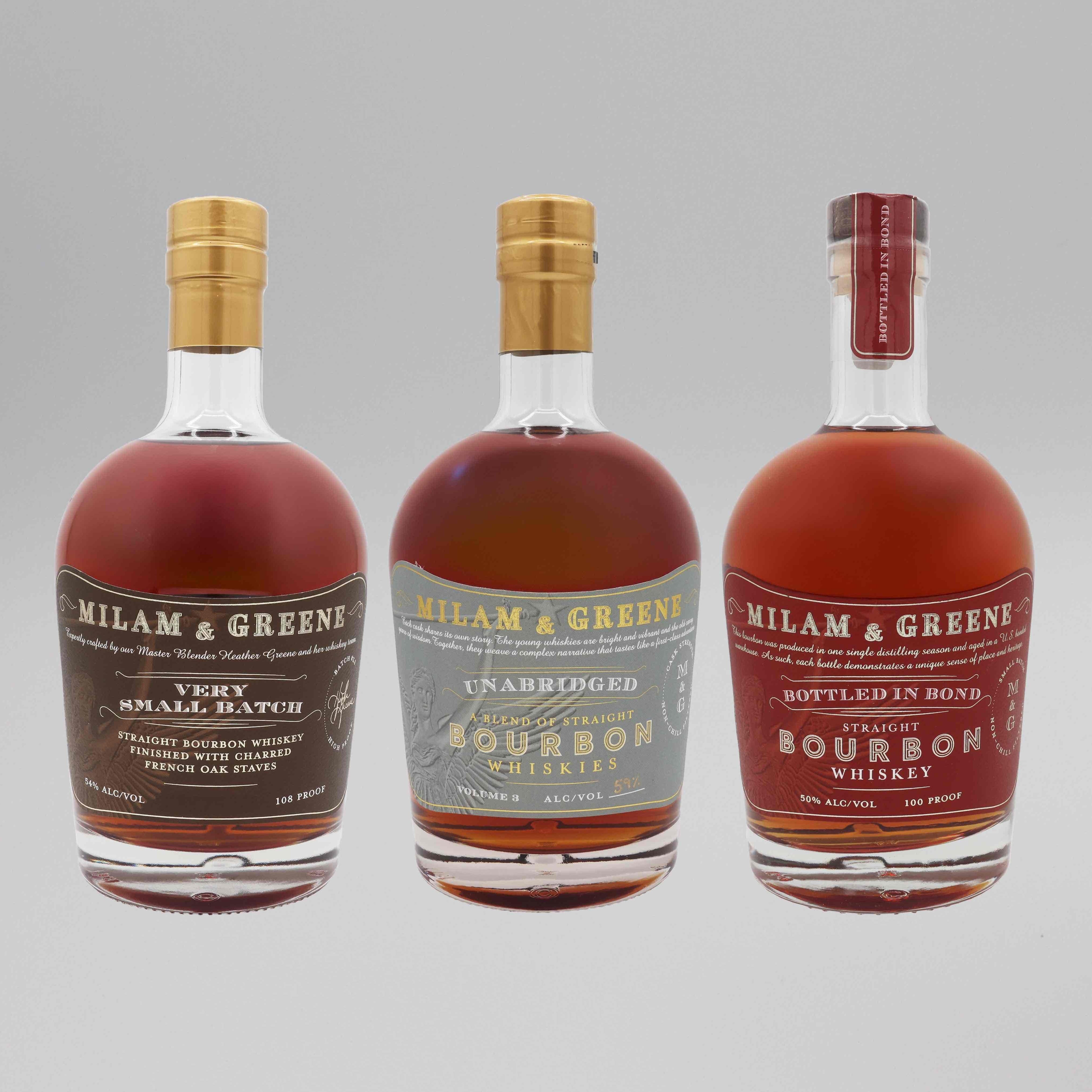 Three bottles from the Milam And Greene Blender’s Reserve Bourbon Bundle stand side by side against a gray background, showcasing the Very Small Batch, Unabridged Bourbon, and Bottled in Bond Straight Bourbon Whiskey.
