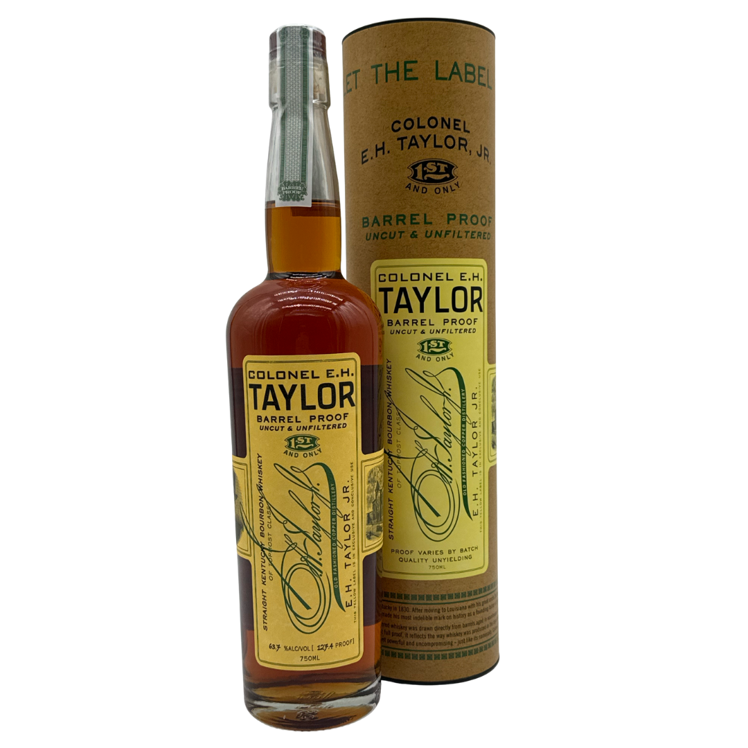 A bottle of Colonel E.H. Taylor, Jr. Barrel Proof Bourbon Batch 14 (127.4 Proof) is displayed with its matching cylindrical box, both featuring yellow labels with black and green text, gold accents, and a clear cap by Colonel E.H. Taylor.