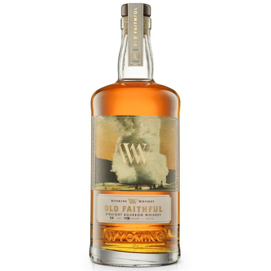 A bottle of Wyoming Whiskey Old Faithful 10 Year Limited Edition, by Wyoming Whiskey, with a gold and cream Yellowstone-inspired label, featuring Old Faithful geyser and a gold WY logo, filled with amber whiskey.