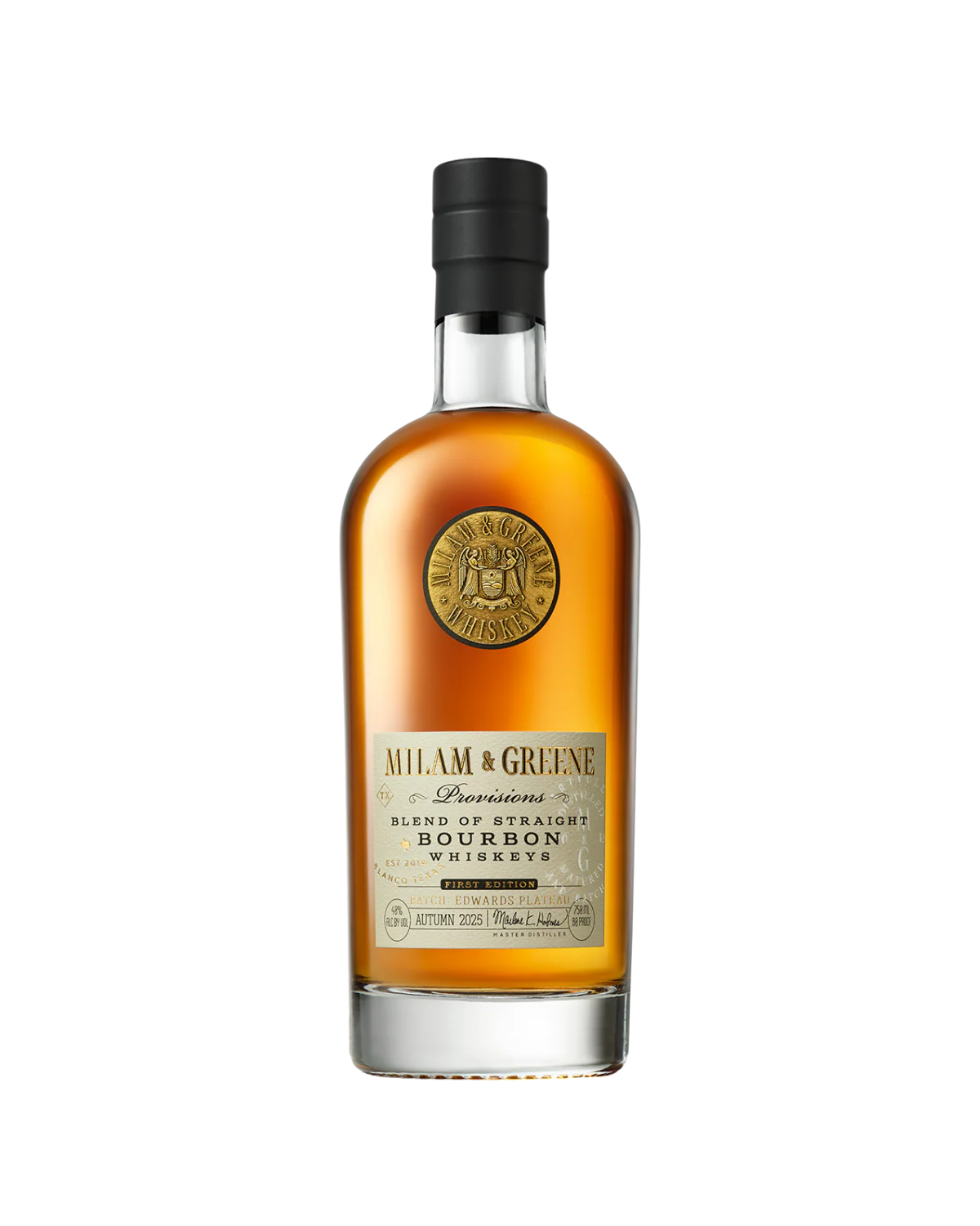 A bottle of Milam And Greene Provisions Bourbon First Edition Autumn 2025 features a black cap, gold seal near the neck, and a label reading “Milam & Greene Bourbon Whiskey.” This Texas craft whiskey glows with an amber hue.